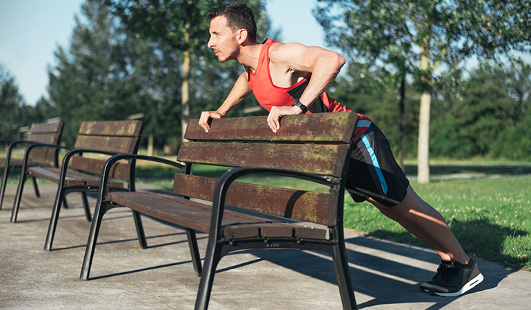 The power pledge exercise makes use of a park bench and targets the shoulders, triceps, chest, and abs.