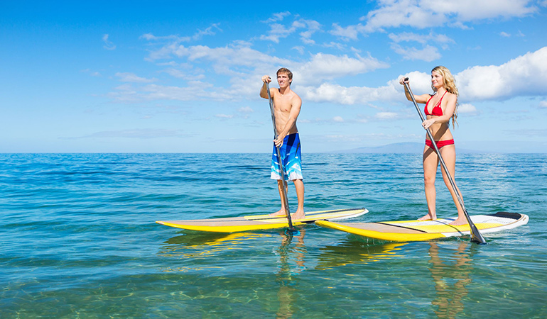 Take to stand-up paddleboarding to improve your balance and engage your core muscles
